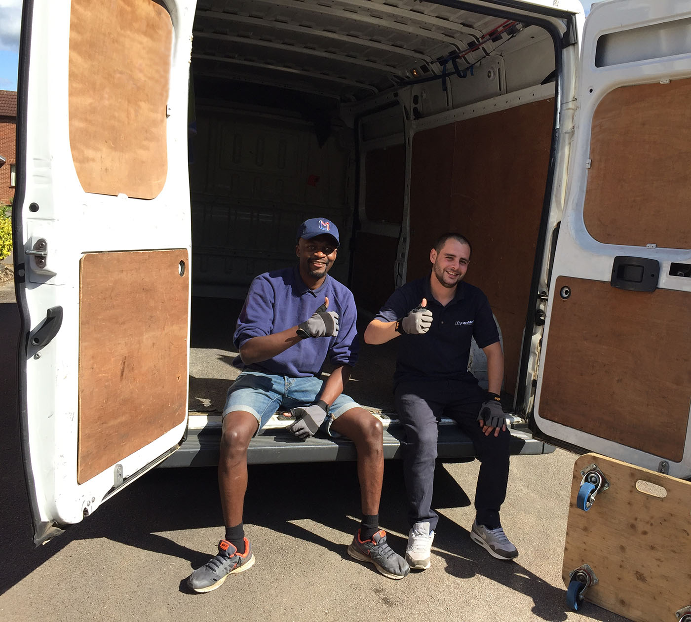 Get in Touch with Van Man Northampton this picture shows two of our drivers / movers sitting at the back of one of our vans with their thumbs up
