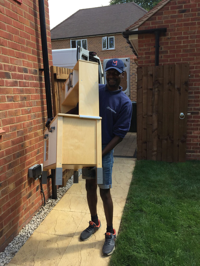 How to Prepare for Your Move with Van Man Northampton this picture shows one of our expert movers carrying a childs kitchen into the family's new home